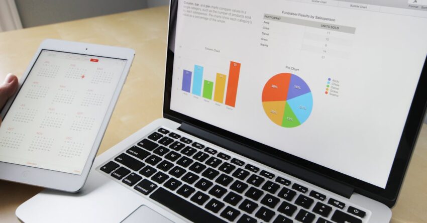Laptop displaying charts and graphs with tablet calendar for data analysis and planning.